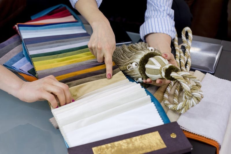 Two women looking through colour samples for curtain